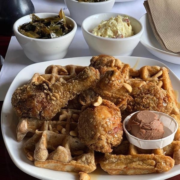 Dame's Chicken & Waffles plate with fried chicken, waffles, collard greens, and potato salad.