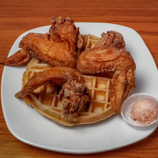 Dame's Chicken & Waffles' fried chicken wings and a waffle with a side of flavored butter.